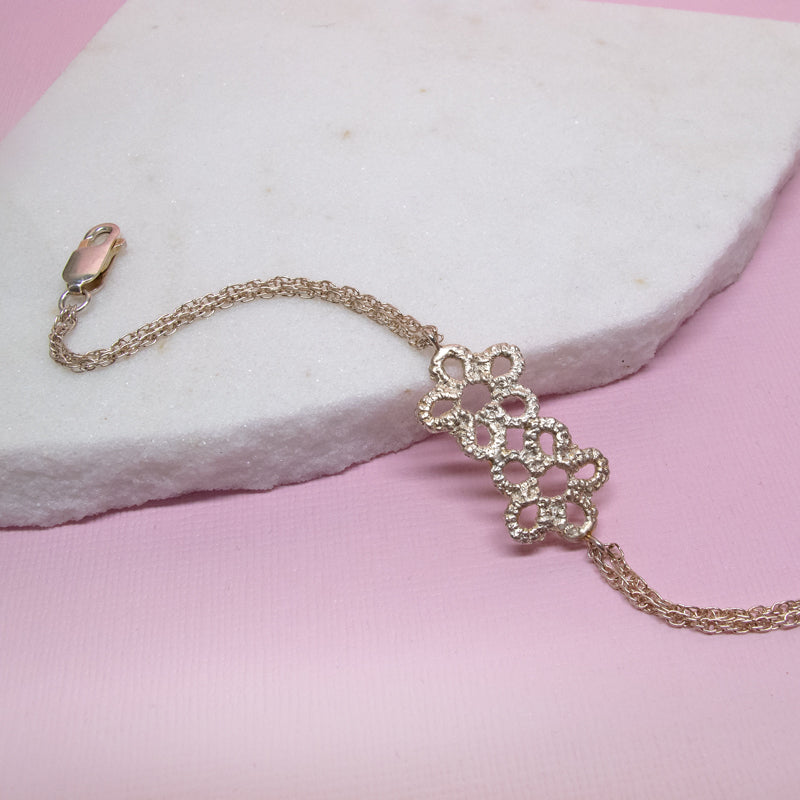 silver flower bracelet on marble and pink background